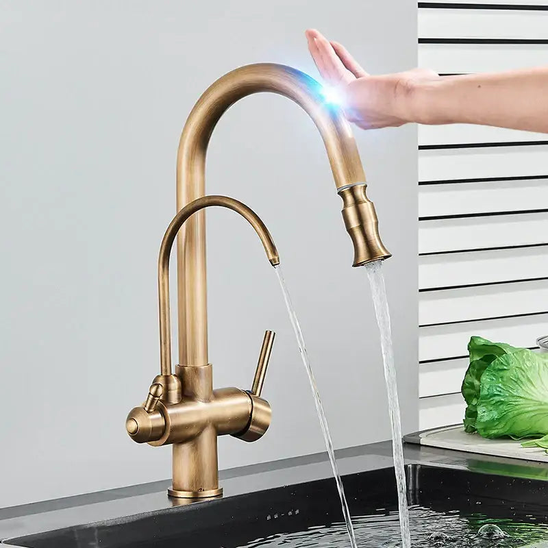 Brass-finished kitchen faucet with curved spout, dual spray settings, and illuminated black touch sensor handle