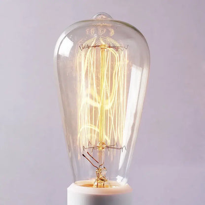 A glowing vintage-style incandescent bulb with intricate filament in decorbites black umbrella wall lights for living room