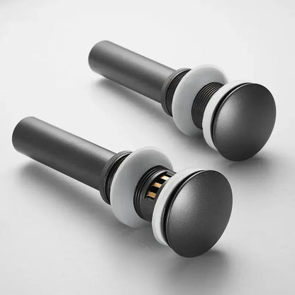 Matte black bathroom sink drain stoppers with white rubber seals and metal stems in brushed gold drain assembly kit