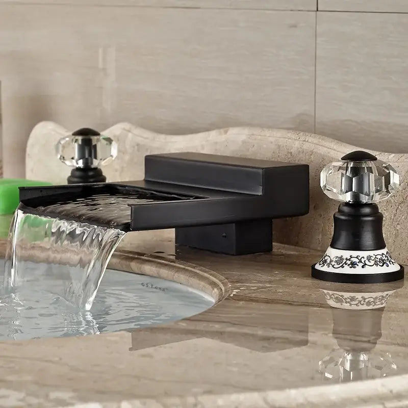 Matte black wide waterfall spout bathroom faucet with black wide waterfall design and crystal knobs on ornate white base