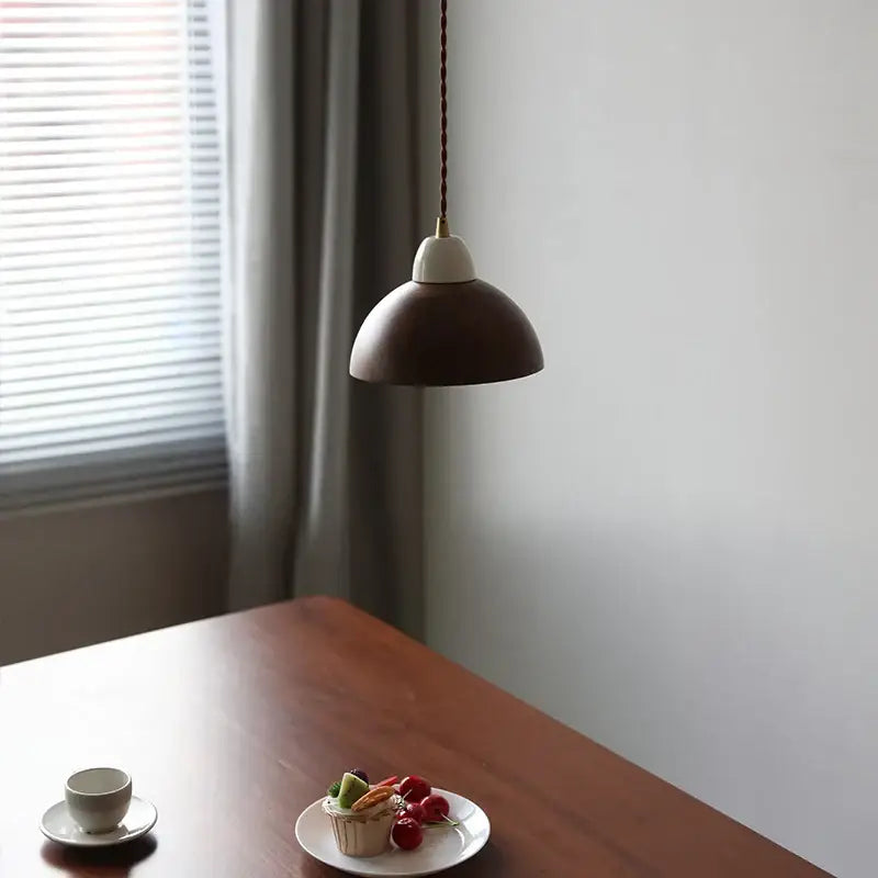 Matte brown and copper ceramic walnut pendant light with a matte brown dome shade and white ceramic base by decorbites
