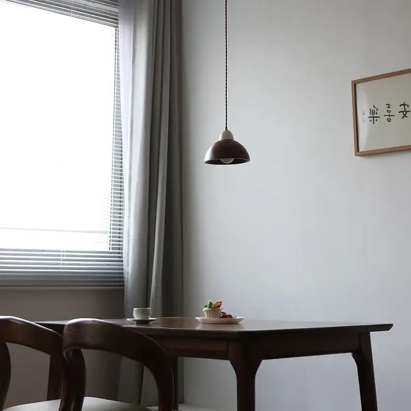 Matte brown and copper ceramic walnut pendant light with dark brown matte dome shade hanging from black cord