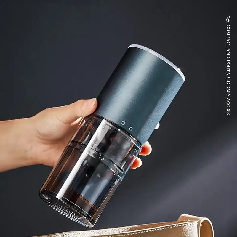 Matte dark teal electric coffee bean grinder with dark green transparent parts and sleek cylindrical design for kitchen use