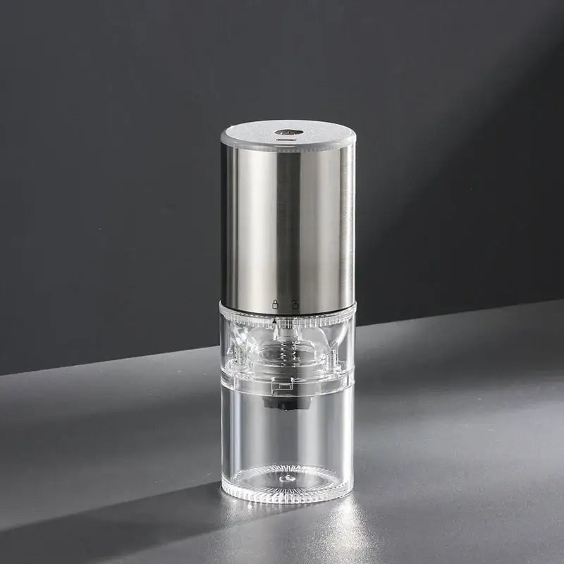 Matte dark teal electric coffee bean grinder with brushed stainless steel top and transparent glass body for kitchen use