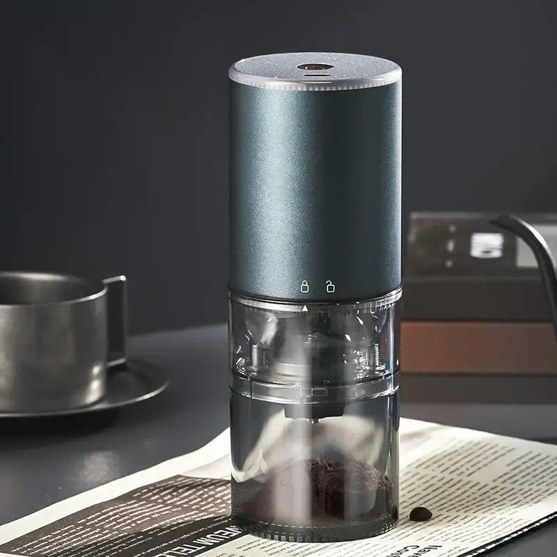 Matte dark teal electric coffee bean grinder with silver accents and transparent chamber for precise grinding
