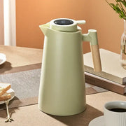 A matte sage green decorbites insulation kettle thermos bottle with a digital temperature display and wooden handle