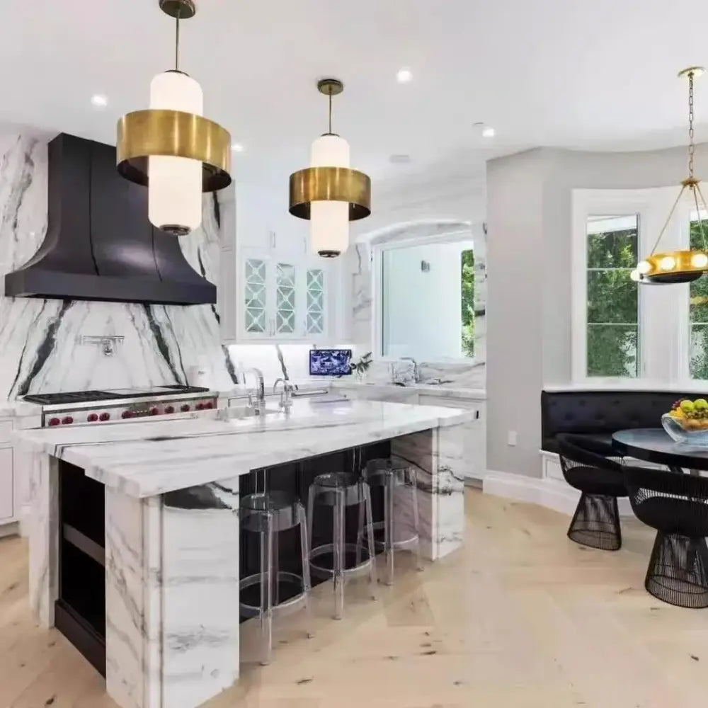 Medieval gold glass brass pendant light hanging above black and white marble kitchen island with sleek modern design
