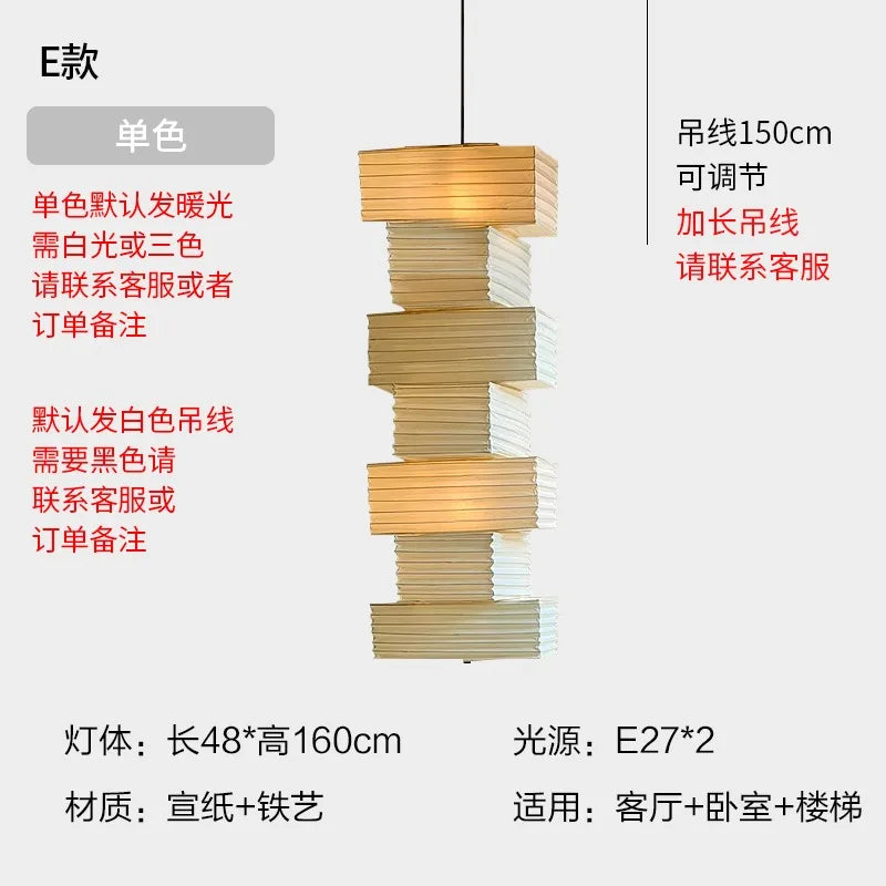 Stacked tiered pendant lights with alternating gold and white paper layers on iron frame akari noguchi yong design
