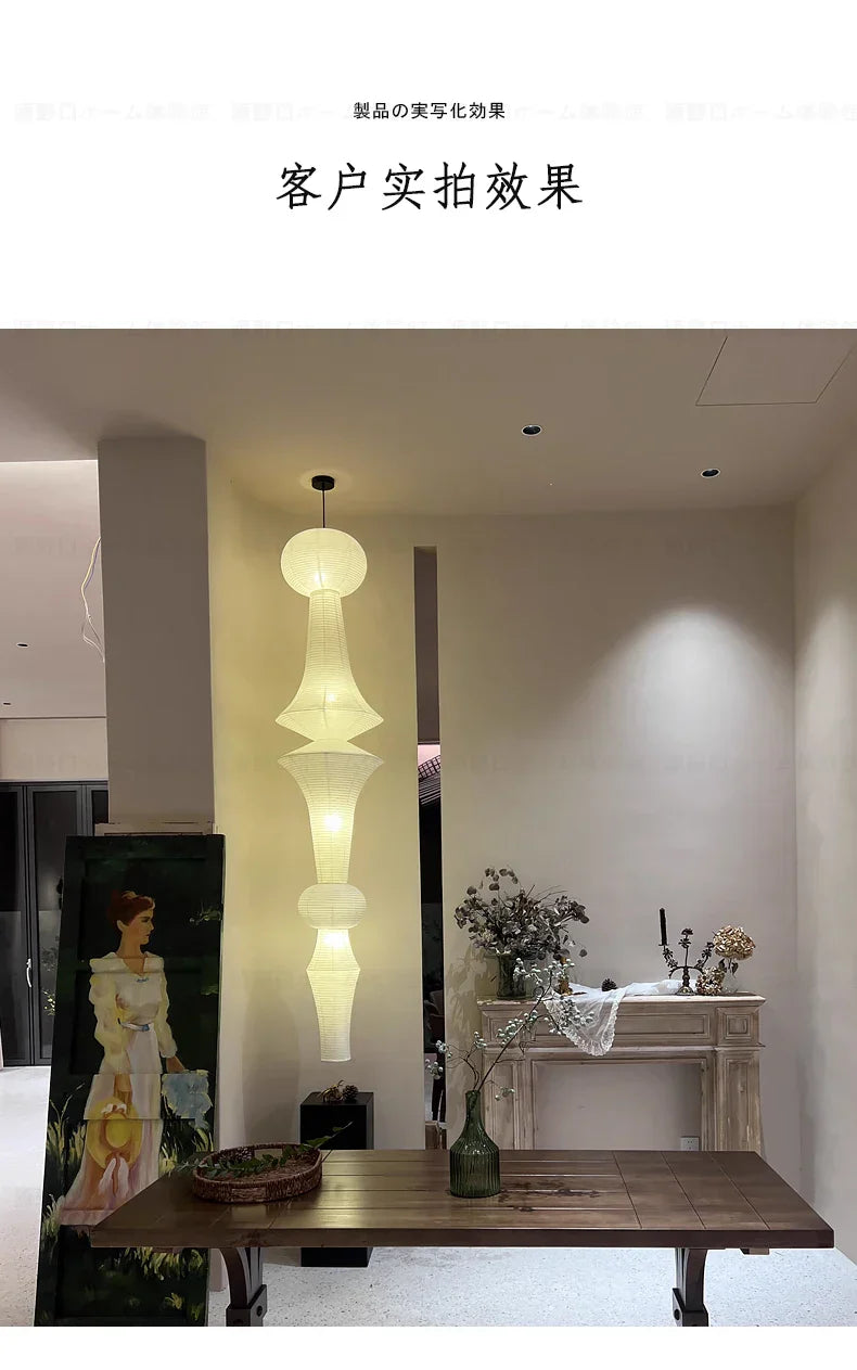 A tall slender akari noguchi yong pendant light with layered white translucent fabric shade for home decor