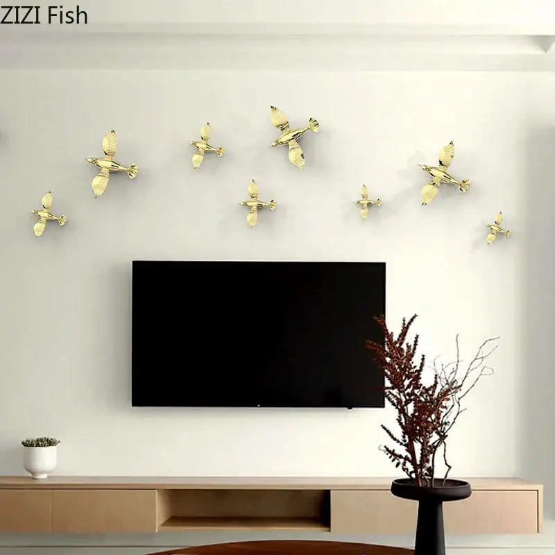 Gold-colored metallic pigeon wall decals arranged in flight pattern above television as living room dove statue decor