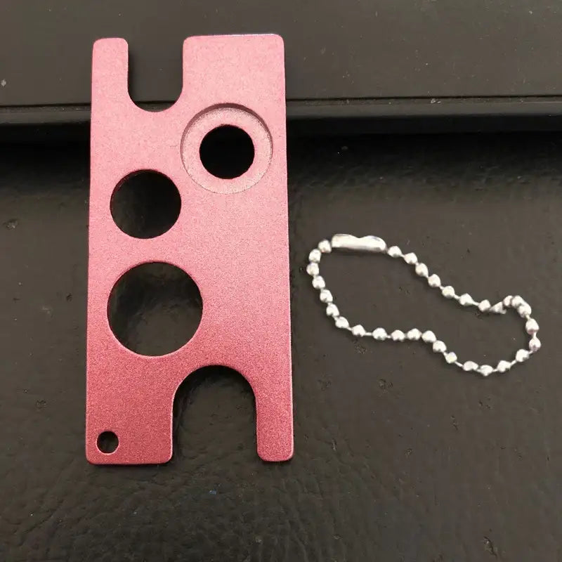 Pink aluminum essential oils opener tool with three circular cutouts and silver ball chain by decorbites essential oils