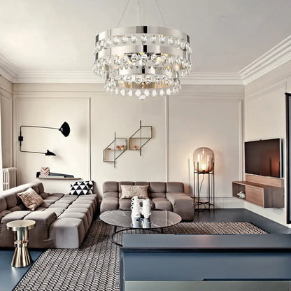 Lámpara de araña metálica multicolor con múltiples luces, decoración de cristal transparente y diseño de anillos escalonados en cromo.
