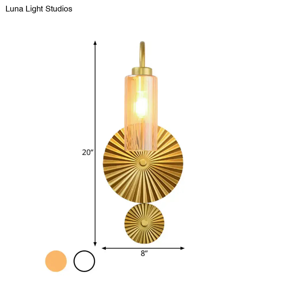 Mid century brass gooseneck wall lamp with gold finish, amber cylindrical glass shade, and sunburst patterned plates