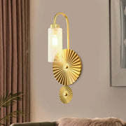 Gold-finished brass gooseneck wall sconce with cylindrical frosted glass shade and sunburst-patterned decorative discs