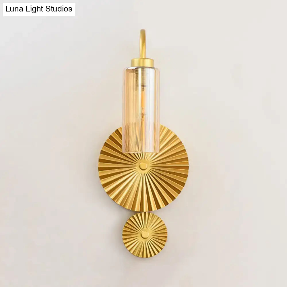 Gold-finished mid century brass gooseneck wall sconce with cylindrical glass shade and sunburst metal plates for bedroom lighting