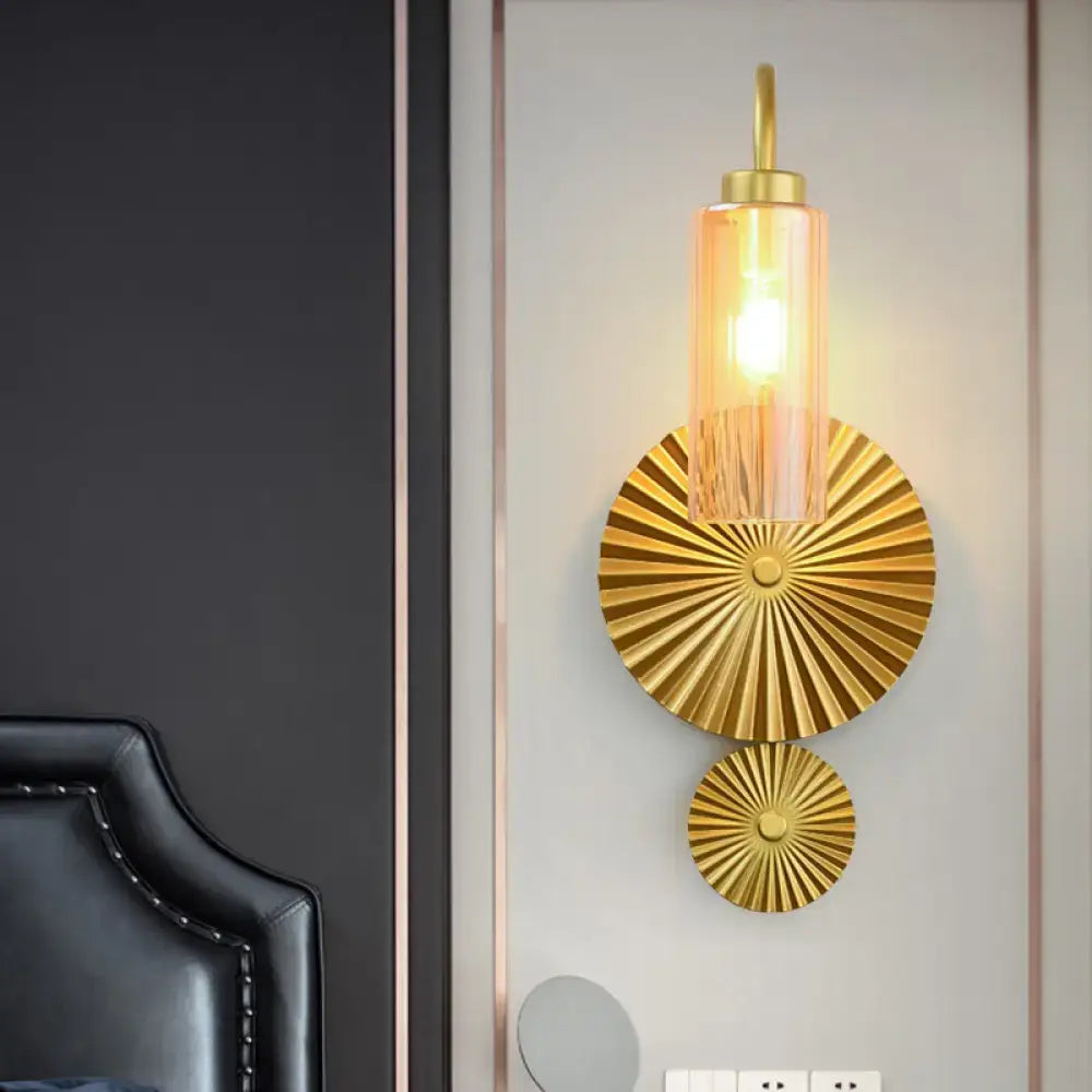 Mid century brass gooseneck wall lamp with gold-toned sunburst discs and cylindrical amber glass shade for bedroom use