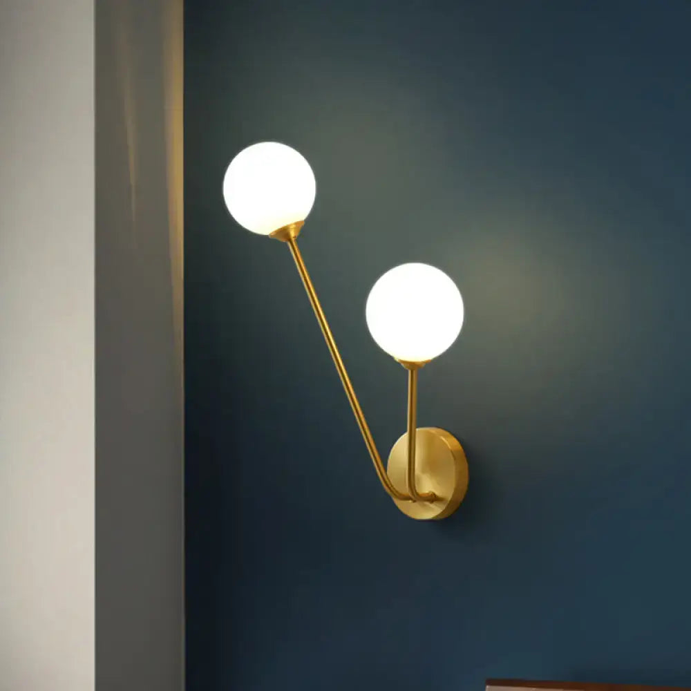 Gold-toned mid century wall light with two opaline glass globes and dual bulb base for living room use