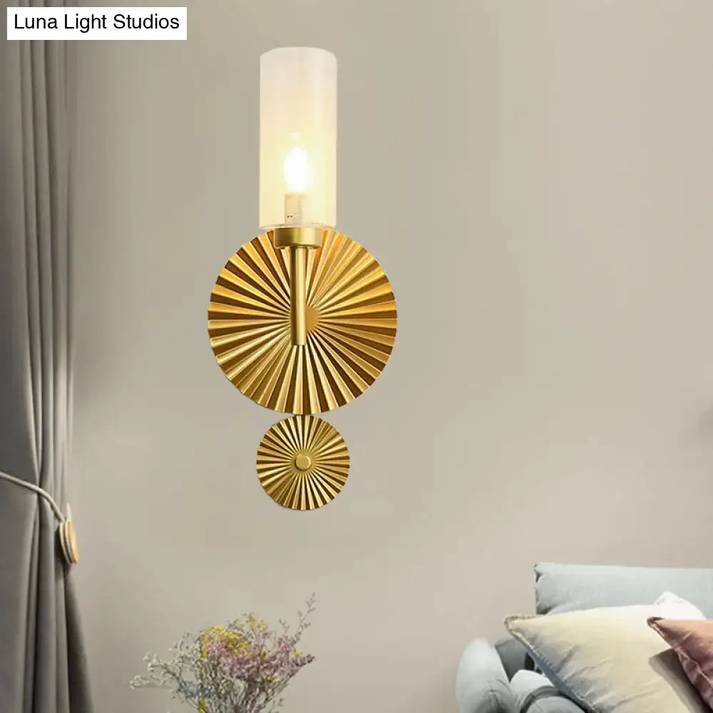 Mid century brass wall sconce with scalloped backplate gold-toned fan-shaped discs and frosted amber glass shade