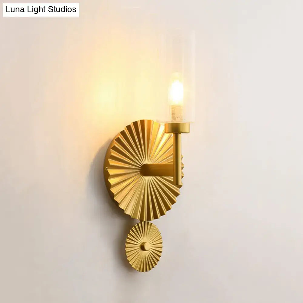Mid century brass wall sconce with gold-toned scalloped backplate and amber glass wall lamp featuring candle bulb