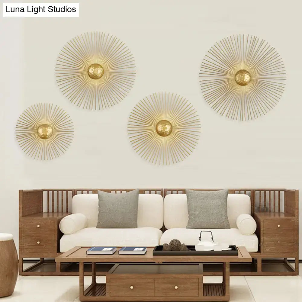 Mid century brass sunburst sconce light fixture with gold-toned metal spokes and central spherical accent for living room
