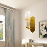 Mid century brass wall lamp with gold-toned finish and clear ribbed glass single light for bedroom use
