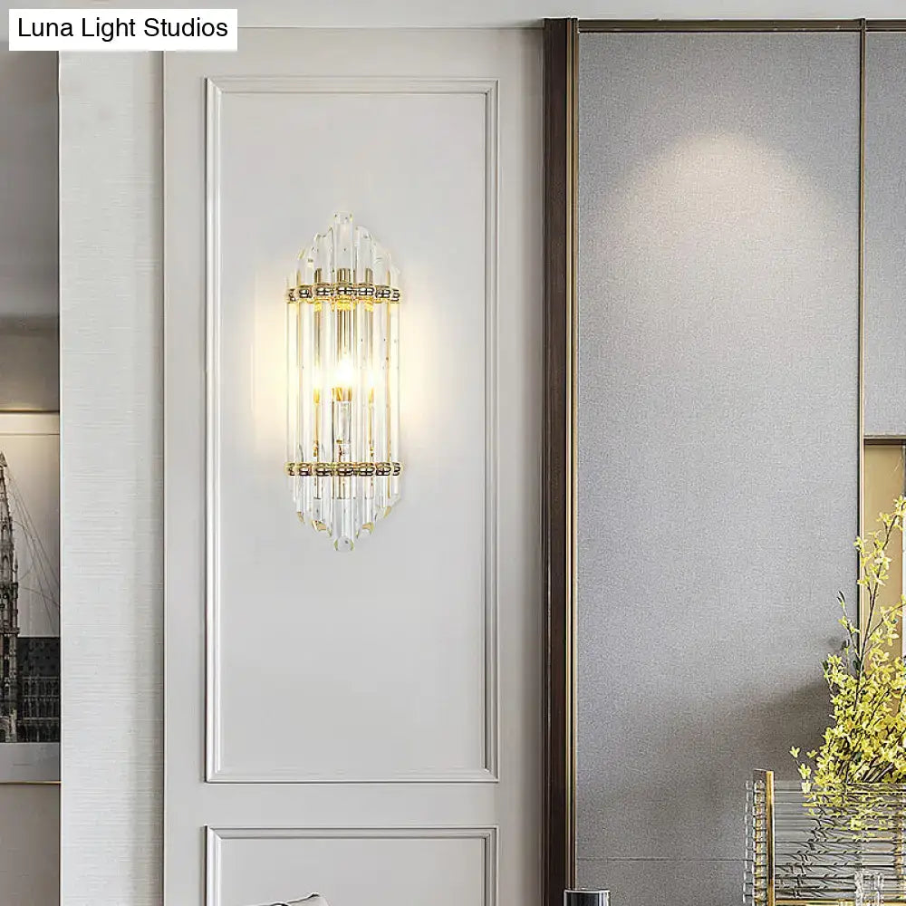 A mid century gold crystal pipe flush wall sconce with clear crystal prisms and warm glow for living room use