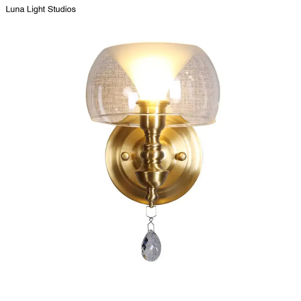 Mid century brass-finished wall sconce with a flared textured glass shade and a crystal droplet pendant for bedroom