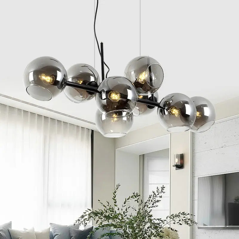 Modern black metal chandelier with smoked glass globes and gold metal accents suitable for 110v-120v led lighting