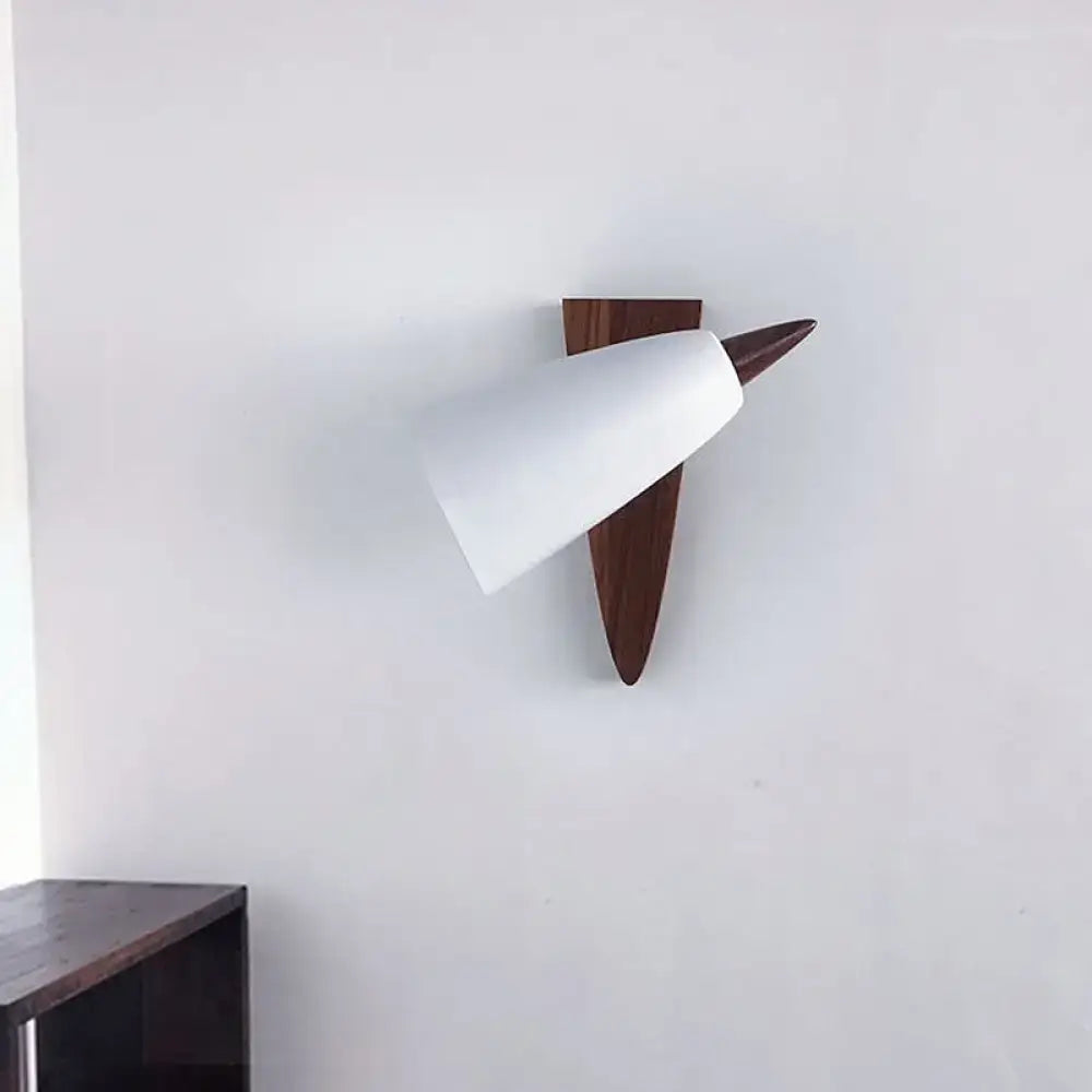 Mid-century white cone metal wall sconce with matte finish and dark wood triangular base for bedroom lighting
