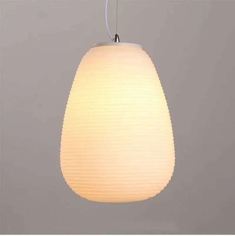 Warm softly glowing pendant light with a milky white glass whorls cocoon shade for dining room ambiance