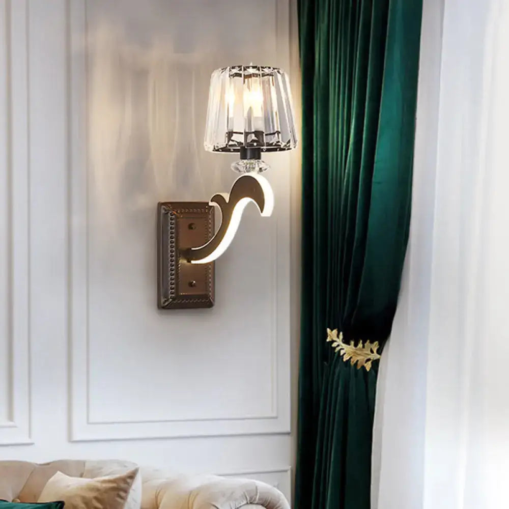 Minimal brass and crystal wall lamp featuring a sleek curved design and cone shade for bedroom lighting