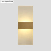 Minimalist acrylic gold wall sconce with a warm diffused glow and central gold-toned metallic accent bar wall lamp