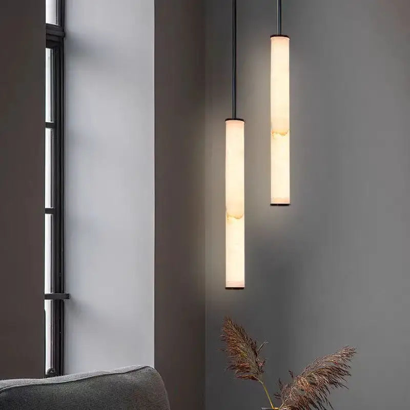 Minimalist amber marble and black pendant light with warm illumination and polished copper accents for kitchen lighting area