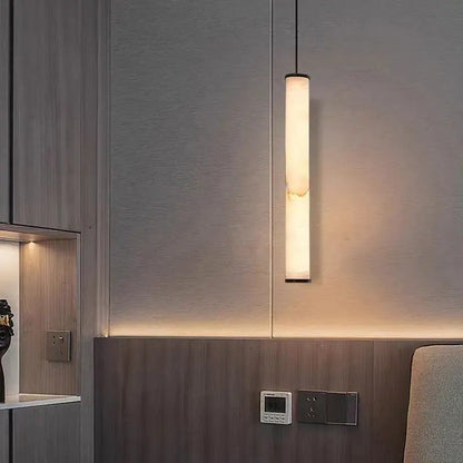 Minimalist amber marble and black pendant light with warm translucent shade and polished copper accents for lighting area