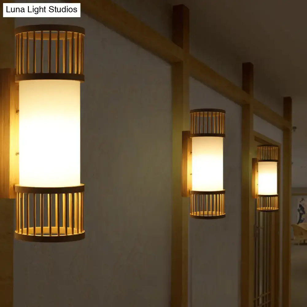 Minimalist warm-toned wall lamp with bamboo slat accents and frosted glass diffuser in a cylinder shade wall sconce design