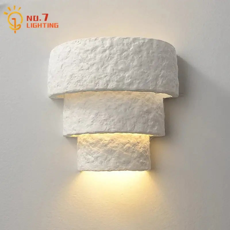 Minimalist bauhaus white gypsum wall lamp with layered design emitting warm light for bedroom use