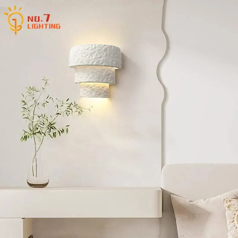 Minimalist bauhaus white gypsum wall lamp with textured layered design providing warm bedroom light