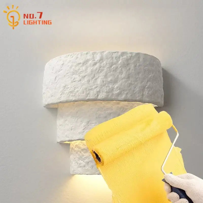 Minimalist bauhaus white gypsum wall lamp with textured stone-style design emitting warm light for bedroom use