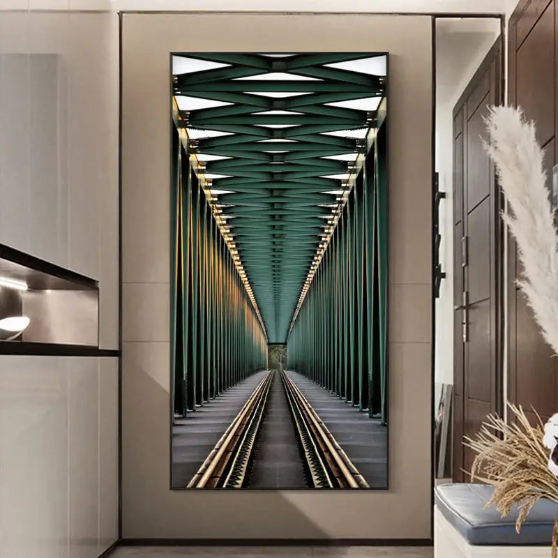 A framed vertical canvas print of green steel train tracks under a lattice ceiling paired with a minimalist beige led wall lamp