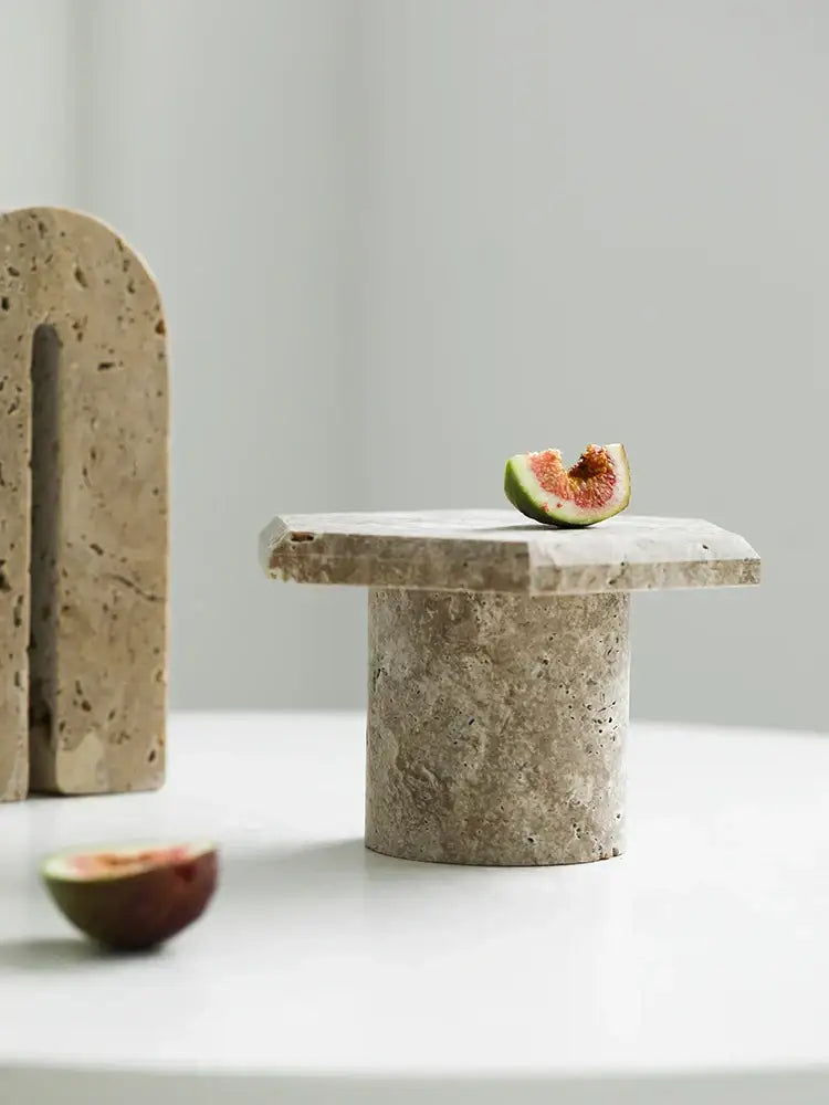 Minimalist beige brown travertine serving tray with a textured hexagon surface and cylindrical stone pedestal base