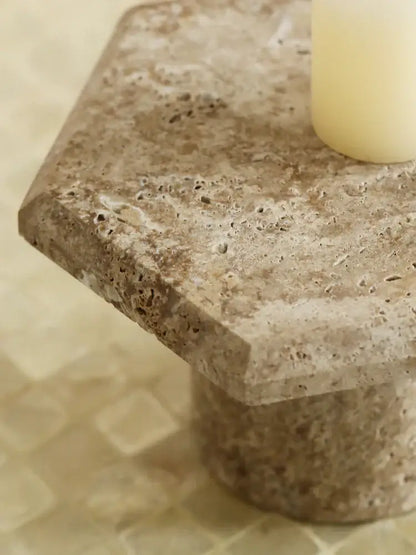 Beige brown travertine serving tray with textured natural surface and rounded edges on a stone pedestal