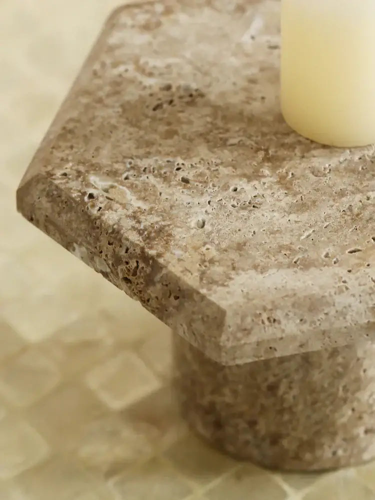 Beige brown travertine serving tray with textured natural surface and rounded edges on a stone pedestal