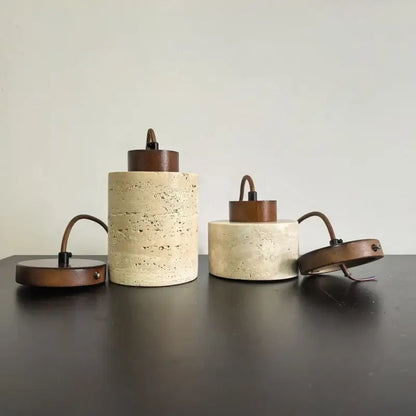 Two cylindrical concrete pendant lights with beige stone shade and dark wood accents for kitchen dining room ceiling tray