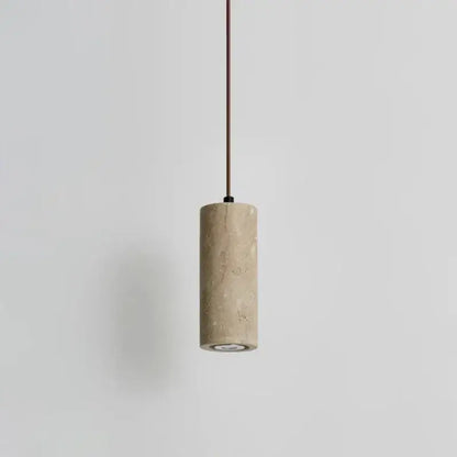 Minimalist beige travertine cylindrical pendant light with textured stone finish and slender brown cord for dining table