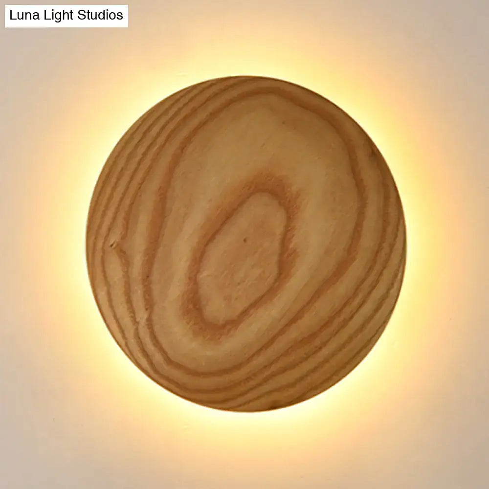 Minimalist beige wood circle led bulb wall sconce with natural grain and warm glowing light for parlor use