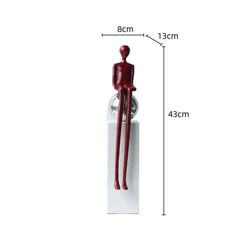 A sleek glossy red metal figurine abstract thinker with elongated limbs on a reflective sphere for living room decor