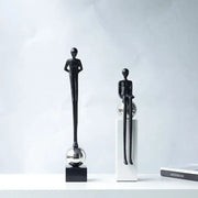 Two minimalist black metal figurines with elongated limbs on reflective spheres for abstract thinker decorbites living room decor