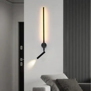 Minimalist black wall lamp with adjustable angle arm and sleek vertical bar emitting warm light by decorbites adjustable angle