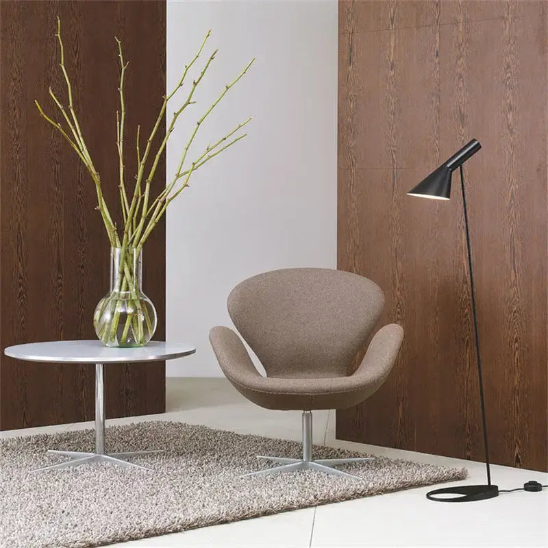 Beige upholstered swivel chair with sleek metallic base next to minimalist black decorbites adjustable led floor lamp