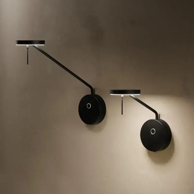 Modern minimalist black wall lamp with adjustable swing arm and sleek curved arms for bedroom lighting